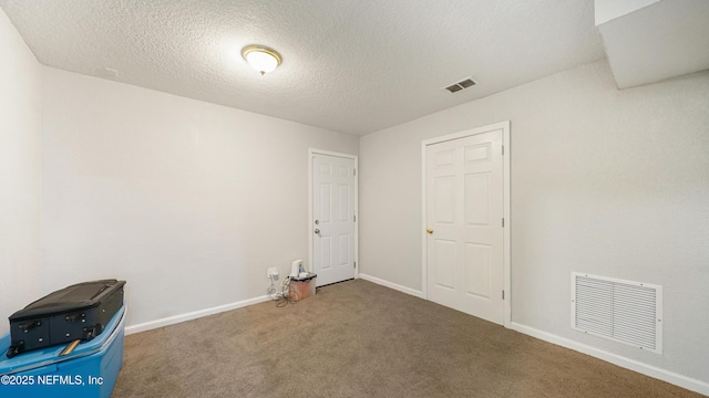 empty room featuring a textured ceiling and carpet floors