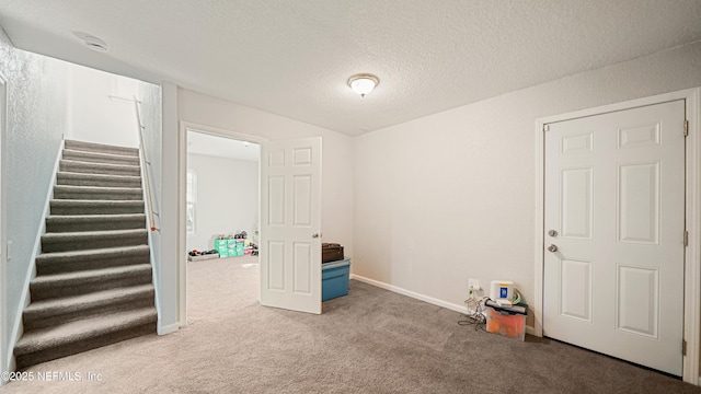 interior space featuring carpet floors and a textured ceiling