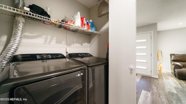 laundry area featuring hardwood / wood-style floors, washer and dryer, and a textured ceiling