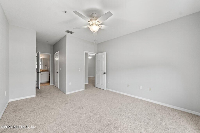 unfurnished bedroom featuring ensuite bathroom, ceiling fan, and light carpet