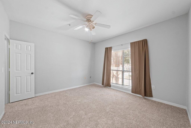 empty room featuring ceiling fan and light colored carpet