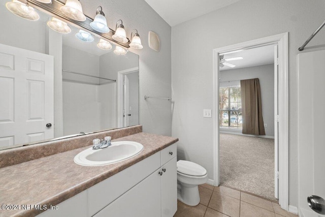 bathroom featuring ceiling fan, walk in shower, tile patterned flooring, toilet, and vanity