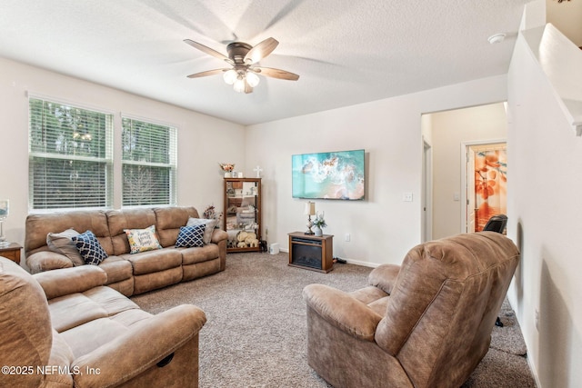 carpeted living room featuring a textured ceiling and ceiling fan