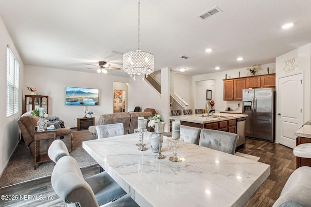 dining room featuring sink, ceiling fan with notable chandelier, and dark hardwood / wood-style floors