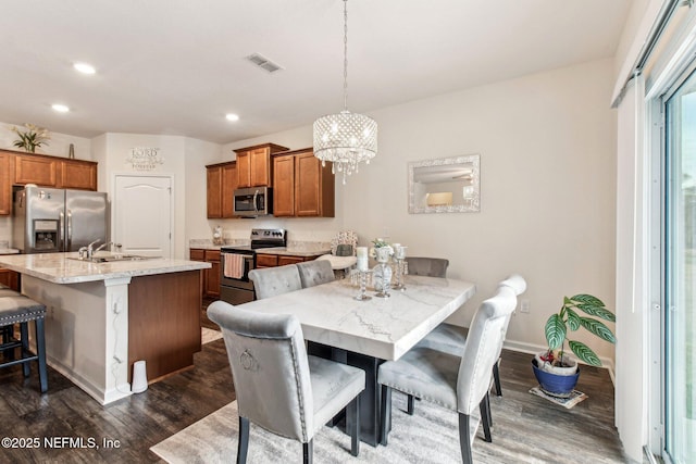 dining space featuring an inviting chandelier, dark hardwood / wood-style floors, and sink