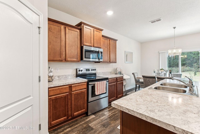 kitchen with a chandelier, pendant lighting, dark hardwood / wood-style flooring, appliances with stainless steel finishes, and sink