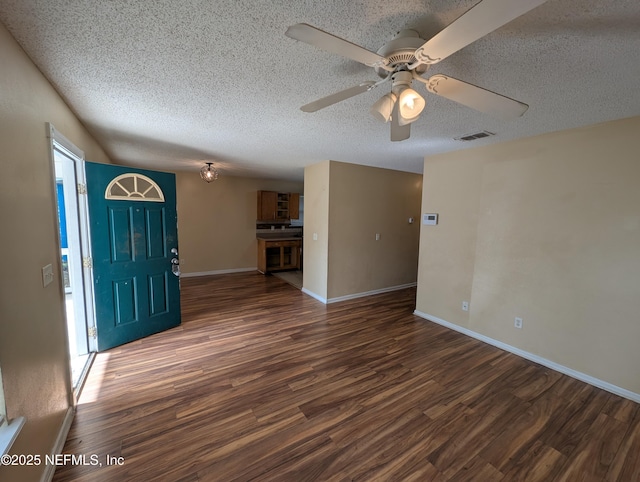 interior space featuring a textured ceiling, dark hardwood / wood-style flooring, and ceiling fan