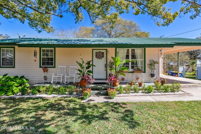 ranch-style home featuring a front lawn, a porch, and a carport