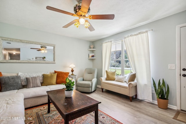 living room with a textured ceiling and light wood-type flooring