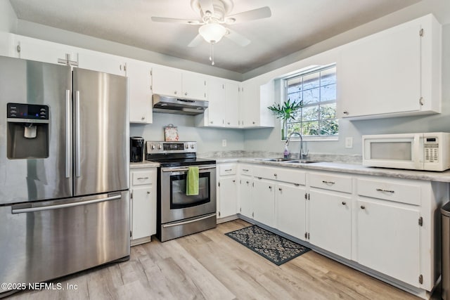 kitchen with sink, white cabinets, light hardwood / wood-style floors, and appliances with stainless steel finishes