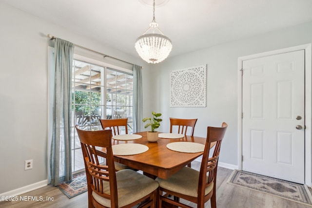 dining space with hardwood / wood-style floors and a chandelier