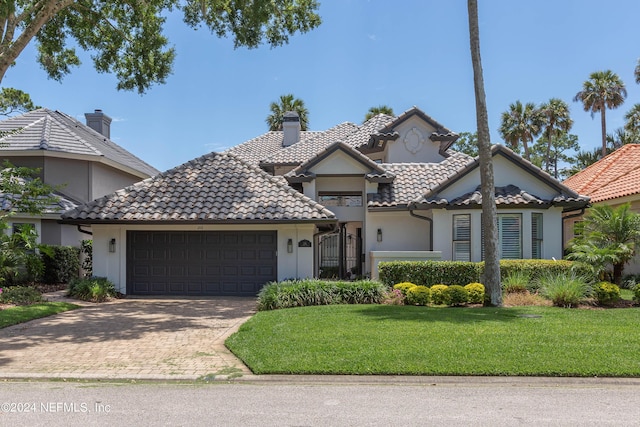 view of front of property featuring a garage and a front lawn