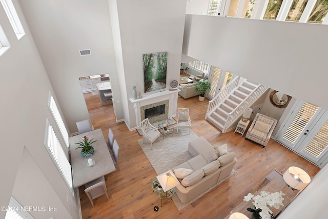 living room with light hardwood / wood-style floors and a high ceiling