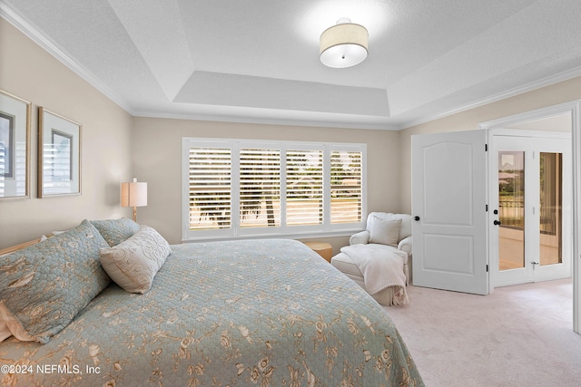 bedroom featuring ornamental molding, carpet floors, a textured ceiling, and a tray ceiling