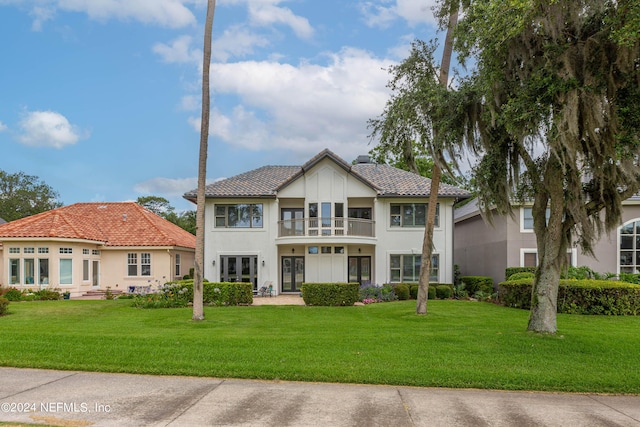 view of front of house featuring a balcony and a front yard