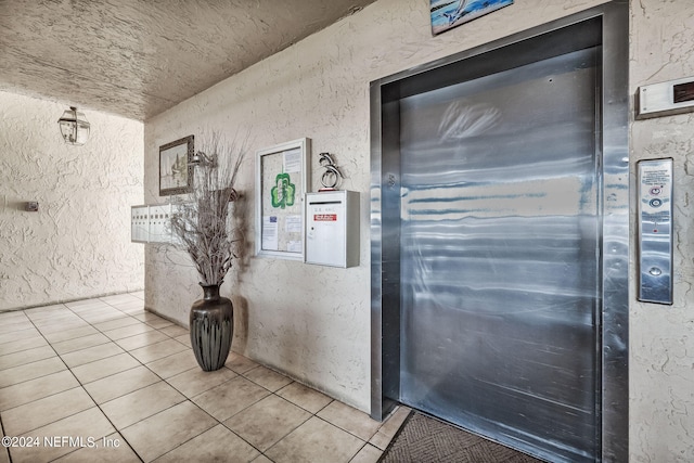 interior space with light tile patterned floors and elevator