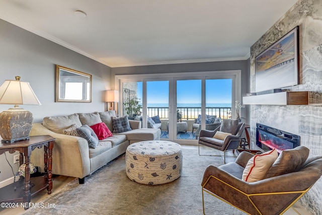 living room with a tiled fireplace, a water view, and ornamental molding