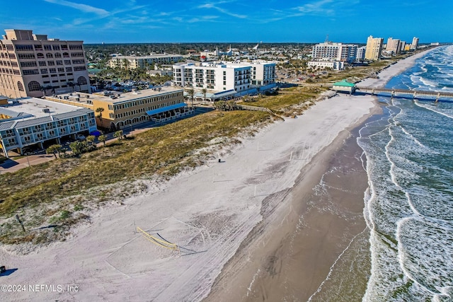 drone / aerial view featuring a beach view and a water view