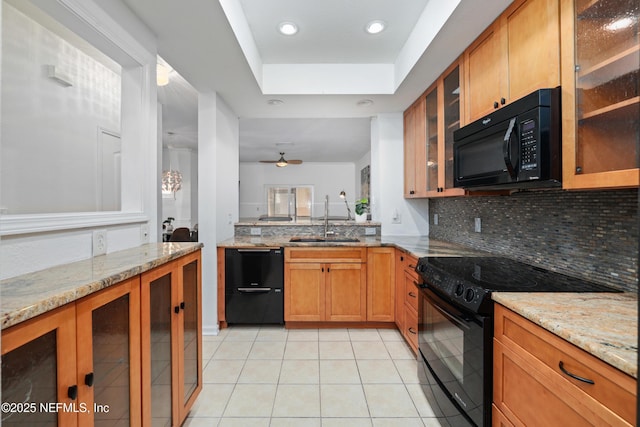 kitchen with light stone countertops, light tile patterned floors, sink, and black appliances