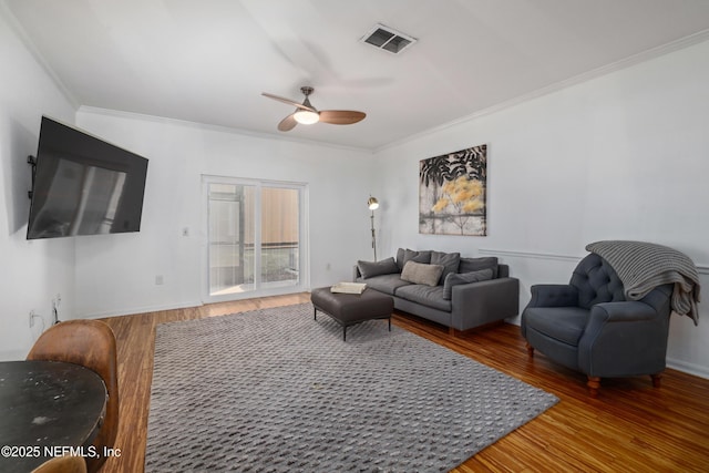 living room featuring ceiling fan, wood-type flooring, and ornamental molding