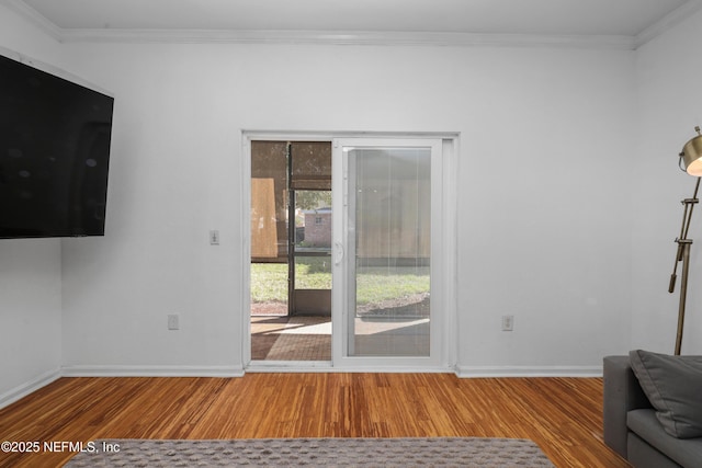 unfurnished living room with hardwood / wood-style floors and crown molding