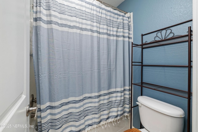 bathroom featuring shower / bath combo with shower curtain and toilet