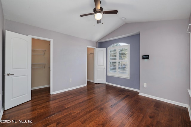 unfurnished bedroom featuring dark hardwood / wood-style flooring, a spacious closet, a closet, and ceiling fan