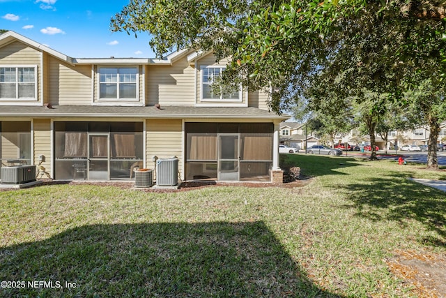 back of property featuring a sunroom, a yard, and central air condition unit