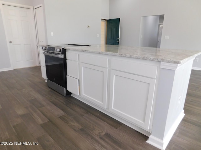 kitchen with stainless steel electric stove, light stone countertops, white cabinetry, and dark wood-type flooring