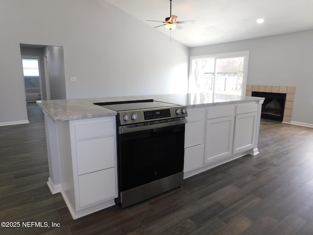 kitchen featuring white cabinets, range, a fireplace, and a healthy amount of sunlight