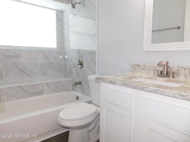 full bathroom featuring tiled shower / bath combo, toilet, and vanity