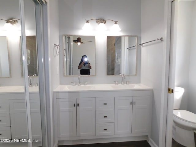 bathroom with vanity, toilet, and ceiling fan