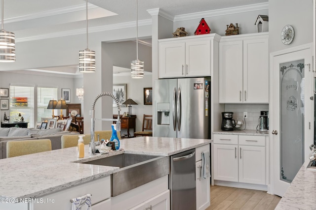 kitchen featuring hanging light fixtures, white cabinetry, sink, and appliances with stainless steel finishes