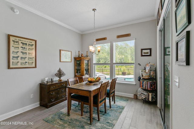 dining room with a chandelier, crown molding, and light hardwood / wood-style floors