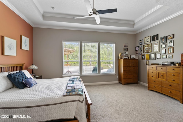 bedroom featuring a raised ceiling, ceiling fan, carpet flooring, and ornamental molding