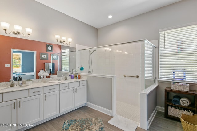 bathroom featuring vanity, a tile shower, and wood-type flooring