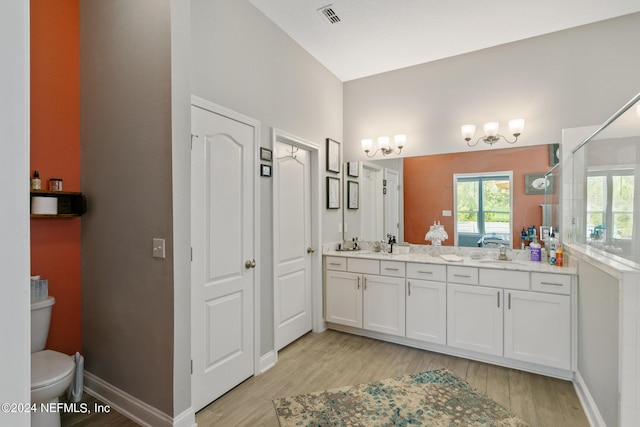 bathroom with walk in shower, hardwood / wood-style floors, vanity, and toilet