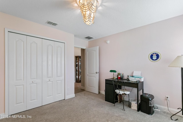 carpeted home office with a chandelier