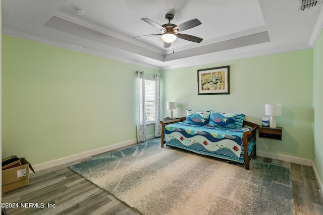 bedroom featuring a tray ceiling, ceiling fan, and crown molding