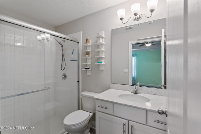 bathroom with a textured ceiling, vanity, toilet, and an enclosed shower