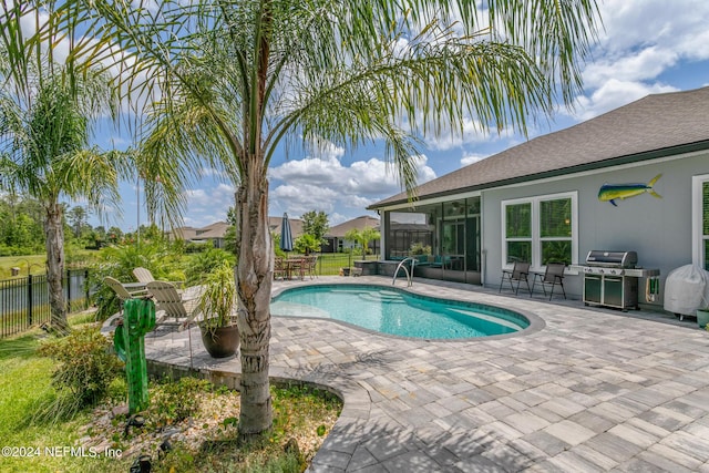 view of pool featuring area for grilling, a sunroom, and a patio