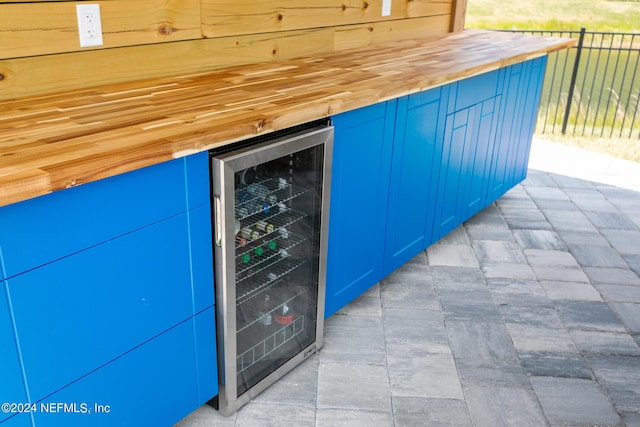 exterior space featuring wood counters, blue cabinets, and beverage cooler