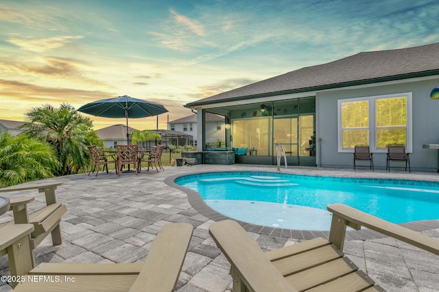 pool at dusk featuring a patio area