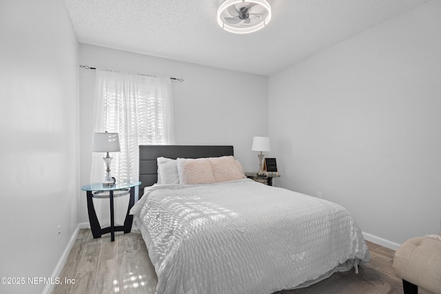 bedroom with light wood-type flooring and a textured ceiling