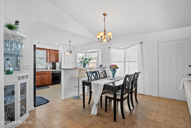 dining area with sink, a notable chandelier, a textured ceiling, vaulted ceiling, and light tile patterned flooring