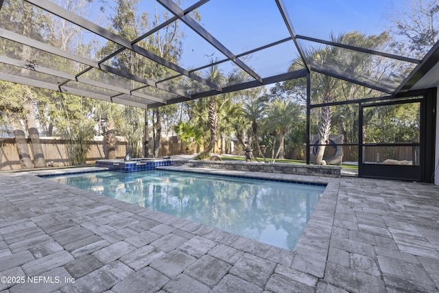 view of pool featuring an in ground hot tub, a patio, and glass enclosure