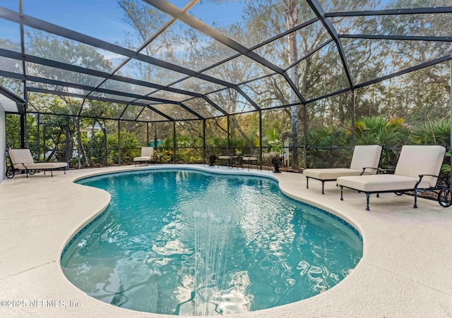 view of pool with glass enclosure and a patio