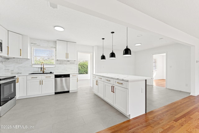 kitchen with white cabinetry, sink, decorative light fixtures, and appliances with stainless steel finishes