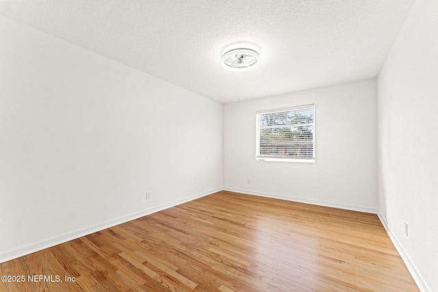 empty room featuring light hardwood / wood-style floors and a textured ceiling