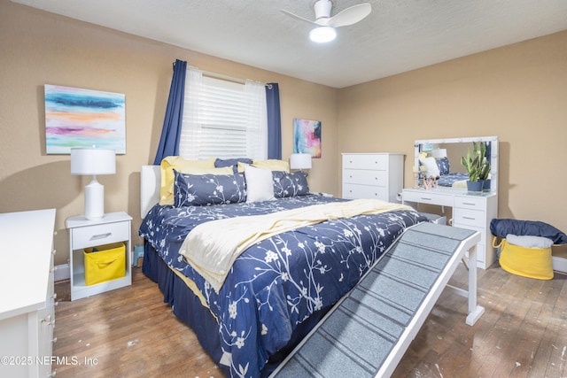 bedroom featuring ceiling fan, dark wood-type flooring, and a textured ceiling